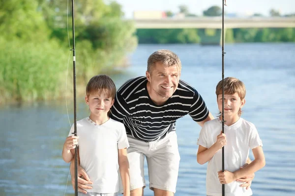 Young father with sons and river on background — Stock Photo, Image