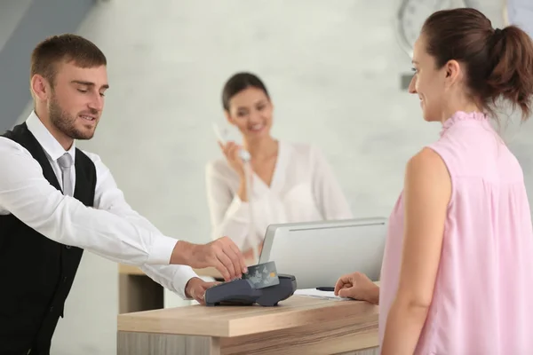 Vrouw betaalt voor hotelkamer bij receptie — Stockfoto