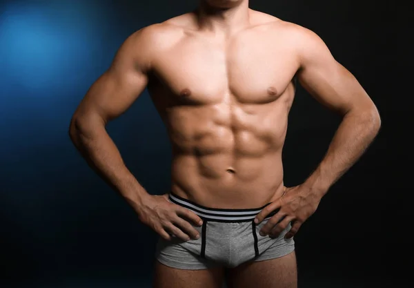 Homem muscular em roupa interior no fundo escuro — Fotografia de Stock