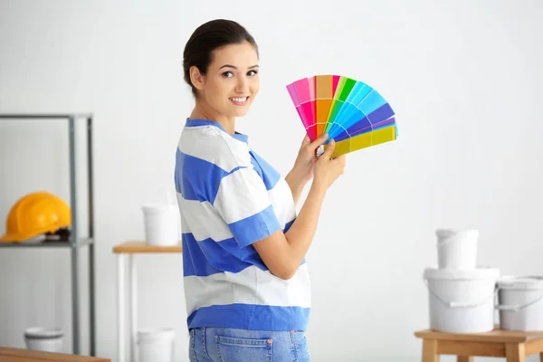 Женский декоратор держит образцы цветовой палитры в помещении — стоковое фото