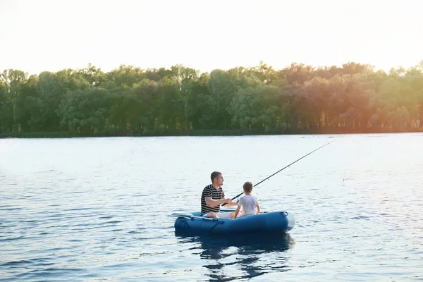 Pai com filho pescando de barco no rio — Fotografia de Stock