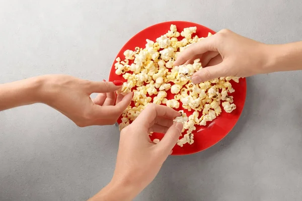 Leute holen Popcorn vom Teller — Stockfoto