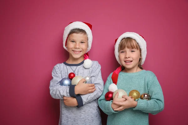 Petits enfants mignons avec décor de Noël sur fond de couleur — Photo