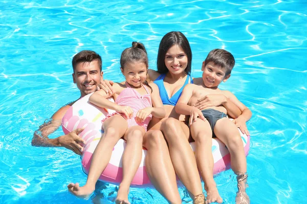 愉快的家庭与充气的圆环放松在游泳池 — 图库照片