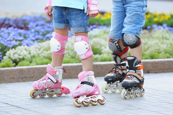 Active boy and girl rollerskating in park — Stock Photo, Image