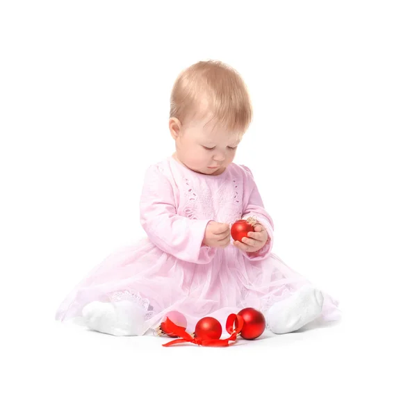 Αξιολάτρευτο μωρό παίζει με χριστουγεννιάτικα στολίδια σε λευκό φόντο — Φωτογραφία Αρχείου