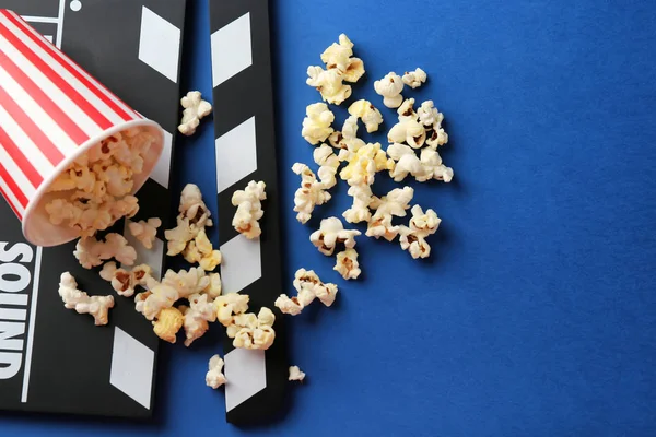 Paper cup with popcorn and movie clapper — Stock Photo, Image