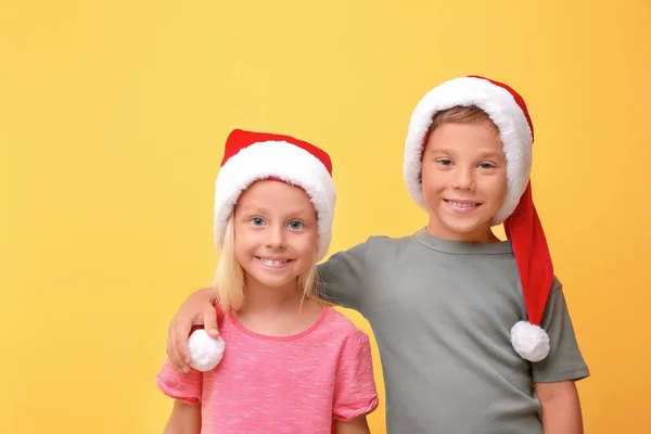 色の背景上のサンタ帽子でかわいい子供たち — ストック写真