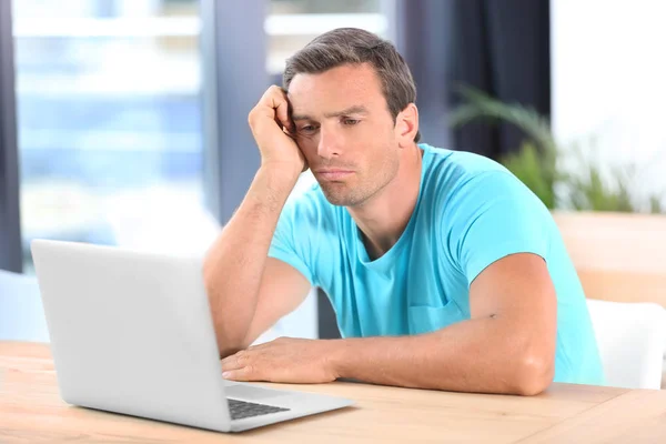 Ung man som använder laptop hemma — Stockfoto