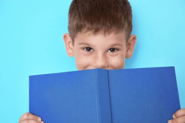 Renklerle ilgili kitabı olan sevimli bir çocuk.