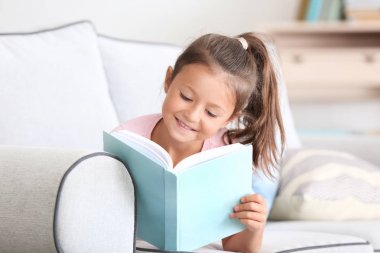 Kitap okuyan sevimli küçük bir kız. 