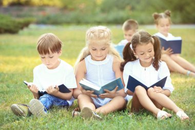 Sevimli küçük çocuklar Park kitap okuma
