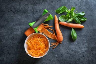 Havuç spagetti ve spiral dilimleyici grunge arka plan üzerinde kase