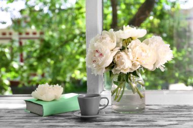 Fincan çay ve çiçekli vazo