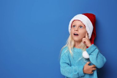 Noel Baba şapkası renk arka plan üzerinde şirin kız