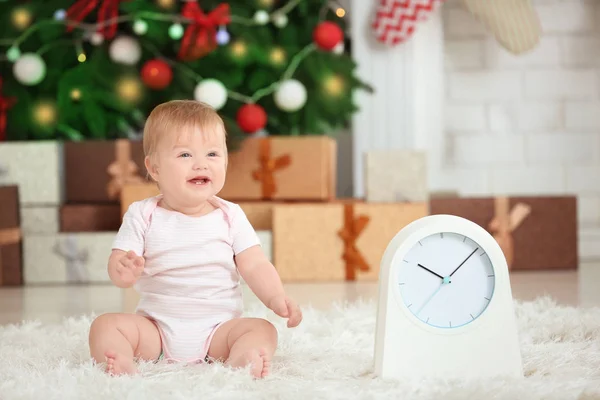 Schattig baby met klok in ingerichte kamer. Christmas countdown concept — Stockfoto