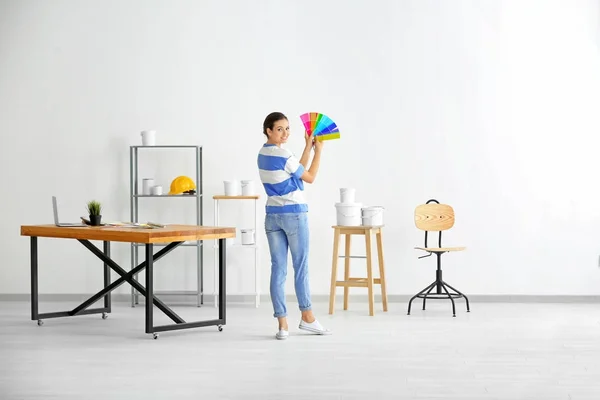 Kvinnliga dekoratör holding färgpalett prover inomhus — Stockfoto