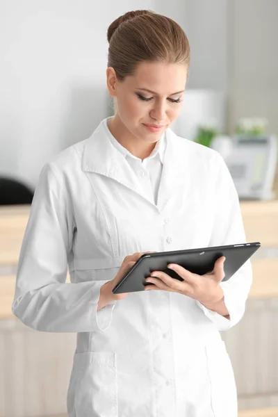 Junge Rezeptionistin hält Tablet in der Hand — Stockfoto