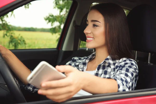자동차를 운전 하는 휴대 전화를 가진 여자 — 스톡 사진