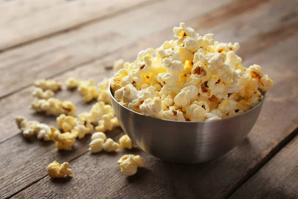 Bowl with popcorn on wooden table — Stock Photo, Image