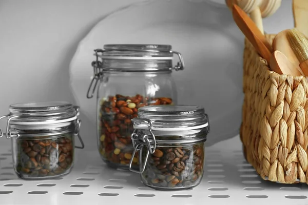Glass jars on shelf of storage — Stock Photo, Image