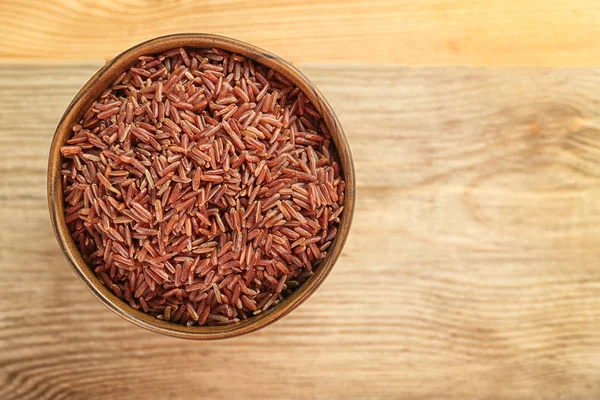 Cuenco con arroz crudo sobre mesa de madera — Foto de Stock