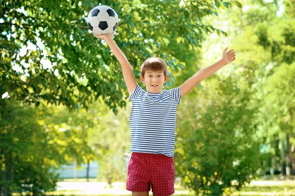 Roztomilý chlapec s fotbalovým míčem v parku — Stock fotografie