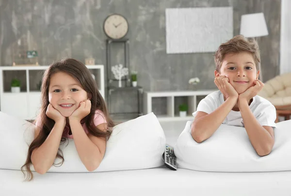Sledování televize na gauči doma roztomilé děti — Stock fotografie