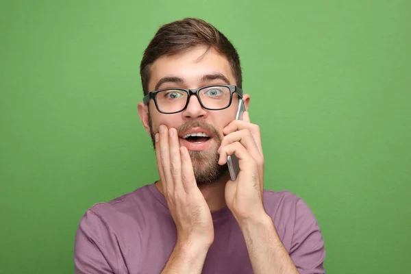Renk arka plan karşı cep telefonla konuşan genç adam — Stok fotoğraf