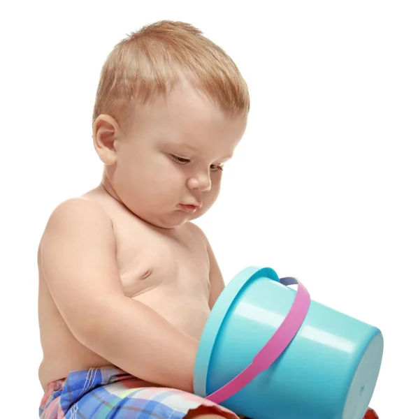 Симпатичный маленький ребенок с ведром для игрушек, изолированный на белом — стоковое фото