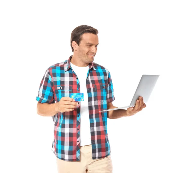 Młody człowiek trzyma laptopa i karty kredytowej na białym tle — Zdjęcie stockowe