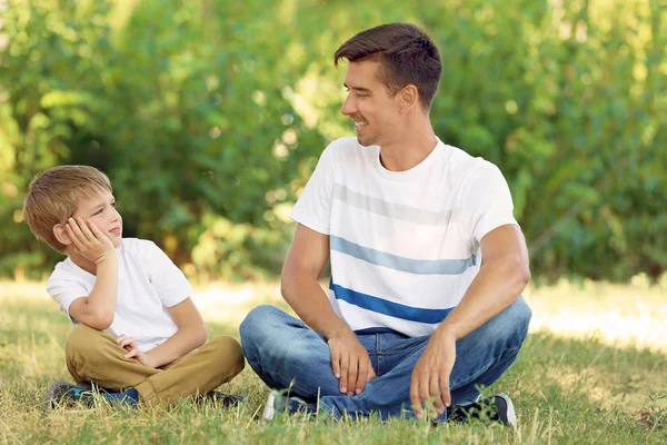 Vader en zoon in park op zonnige dag — Stockfoto