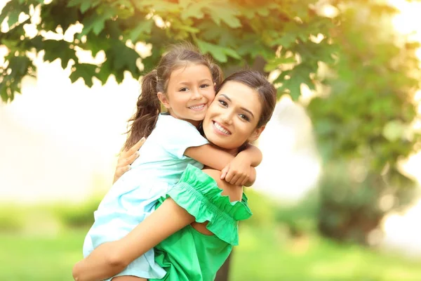 Cute little girl with mother in park on sunny day — Stock Photo, Image