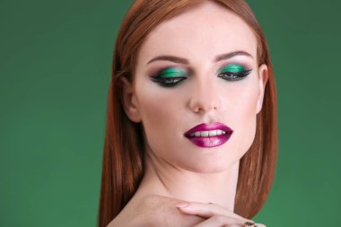 Yeşil zemin üzerine parlak yeşil makyaj ile güzel kızıl saçlı kadın