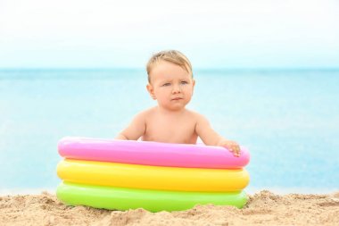 Sahilde küçük şişme havuzda şirin bebek