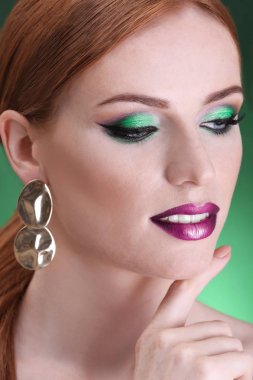 Yeşil arka plan, closeup parlak yeşil makyaj güzel kızıl saçlı kadın