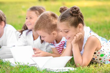 Sevimli küçük çocuklar Park kitap okuma