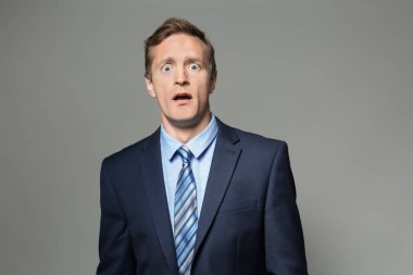 Gri arka plan üzerinde takım elbiseli duygusal adam