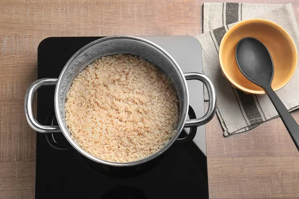 Кастрюля с коричневым рисом на плите — стоковое фото