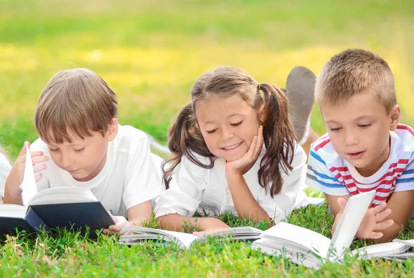 Cute little children reading books in park — Stock Photo, Image