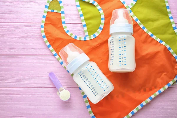 Composition with milk formula and baby bibs — Stock Photo, Image