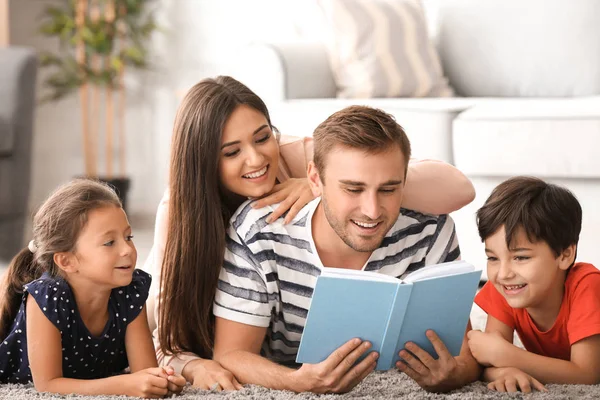 Happy family reading book at home — Stock Photo, Image