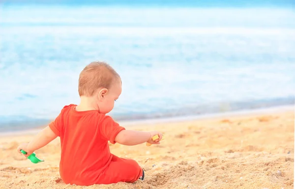Niedliche kleine Junge spielt mit Spielzeug am Strand — Stockfoto