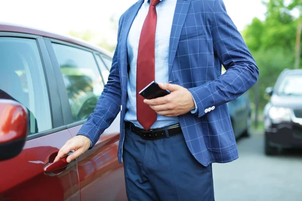 Stilig framgångsrik affärsman nära bil utomhus — Stockfoto