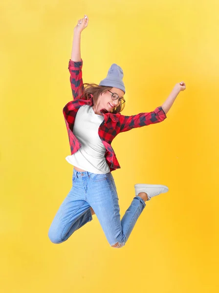 Hoppa tonåring flicka på färg bakgrunden — Stockfoto