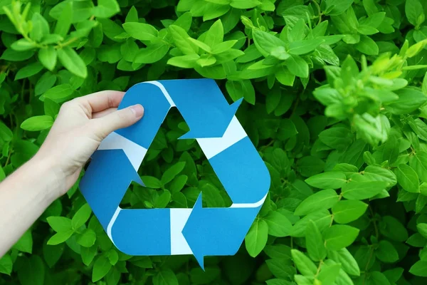 Kobieta trzyma symbol recyklingu na zewnątrz — Zdjęcie stockowe