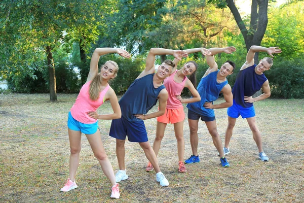 Group of young people doing exercise outdoor — Stock Photo, Image