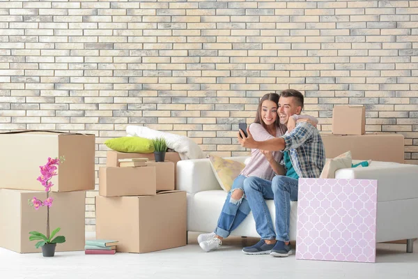 Jonge gelukkig koppel nemen selfie op sofa in kamer nieuwe thuis — Stockfoto