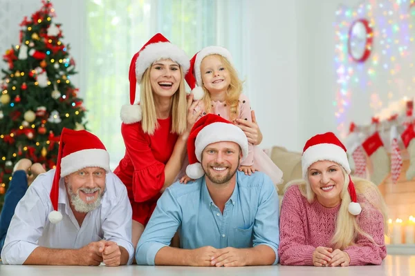 Familia feliz en los sombreros de Papá Noel celebrando la Navidad en casa —  Fotos de Stock