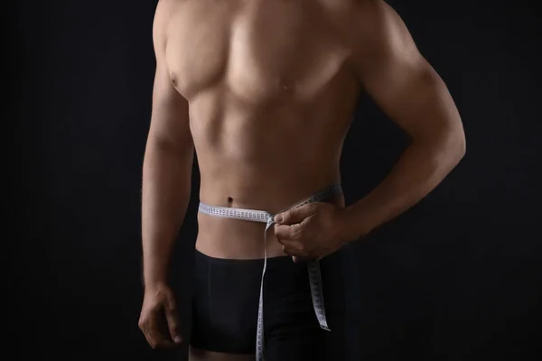 Sporty man measuring his waist — Stock Photo, Image